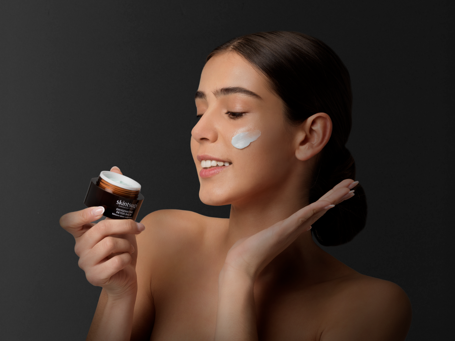 Dunkelhaariges Modell verwendet Detox Nachtpflegebalsam im Gesicht